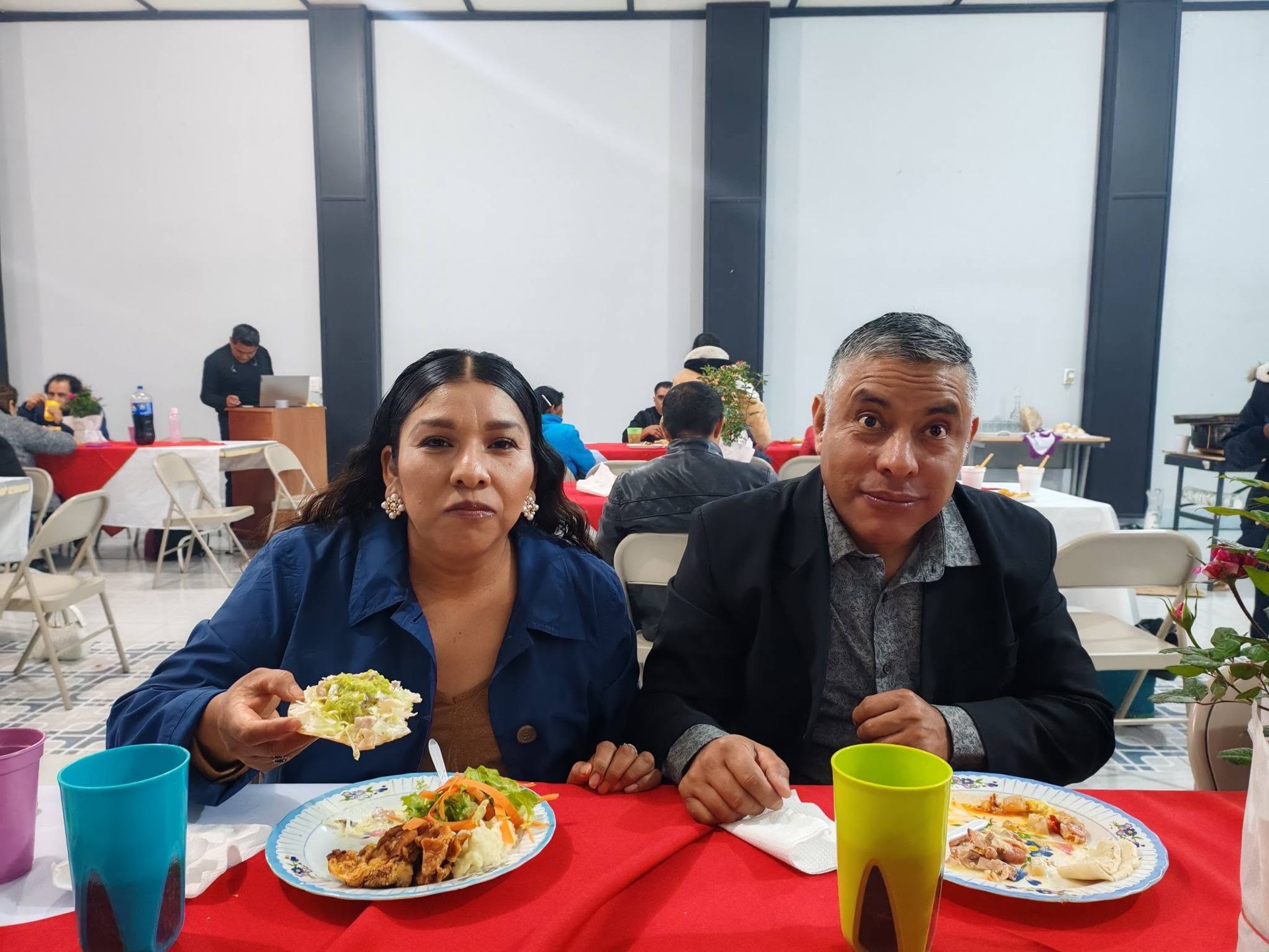 Personas sentadas a una mesa mientras comparten alimentos.
