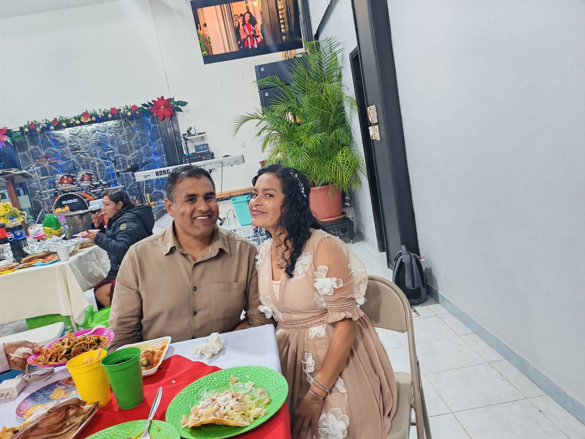 Dos personas sentadas a una mesa dentro del salón.