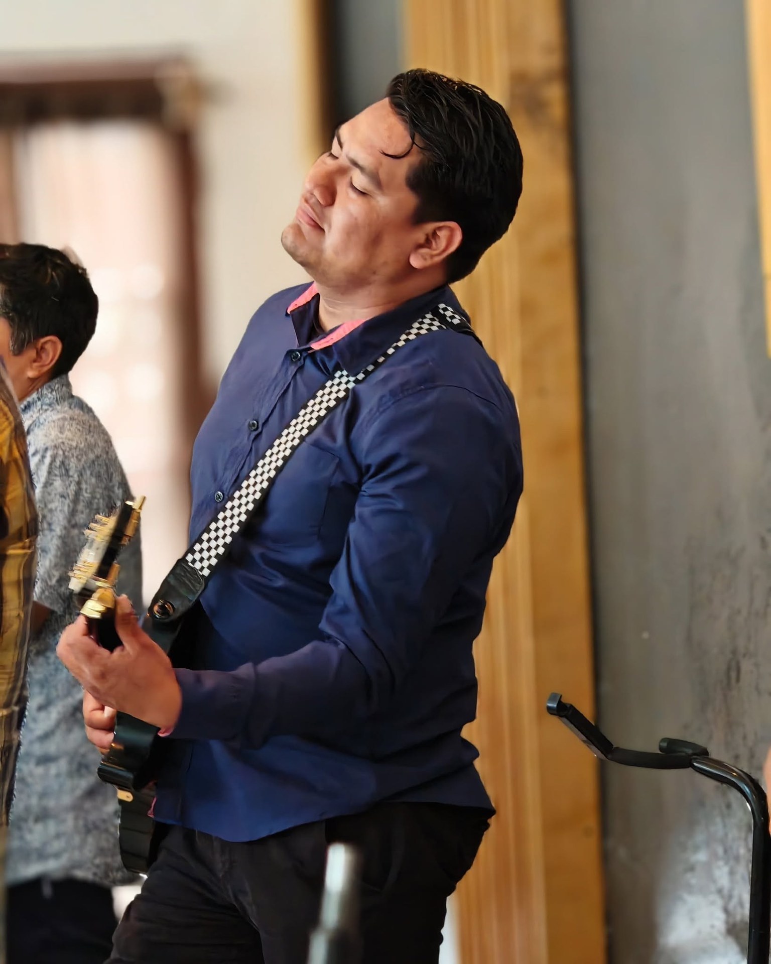 Persona con guitarra durante una presentación musical.