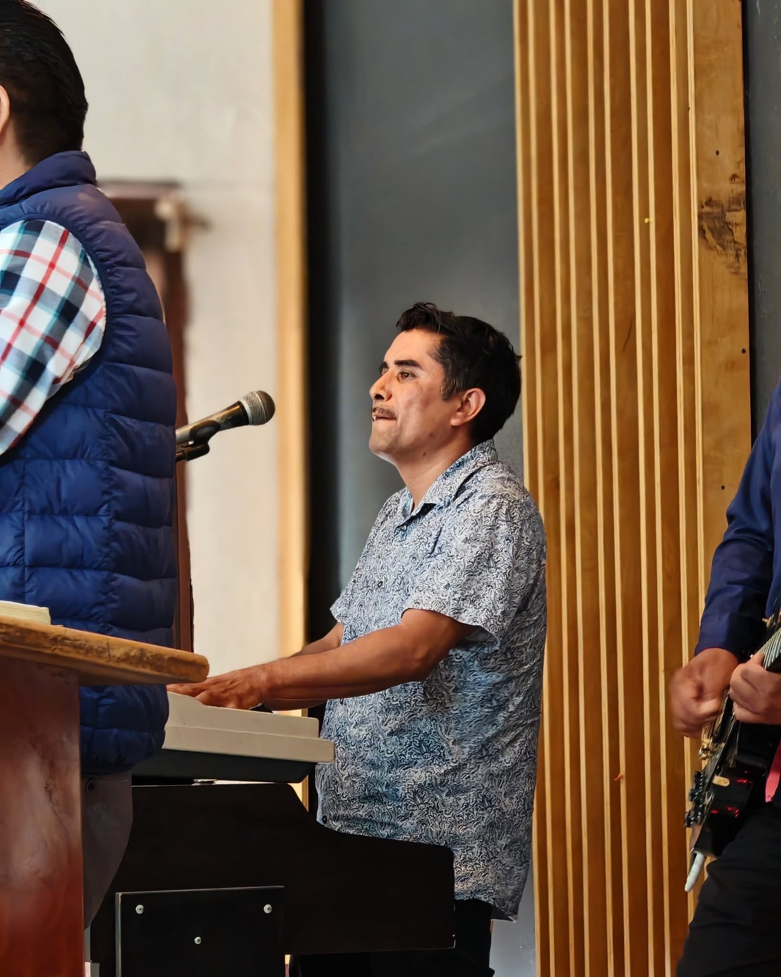 Persona con teclado y micrófono durante una presentación musical.