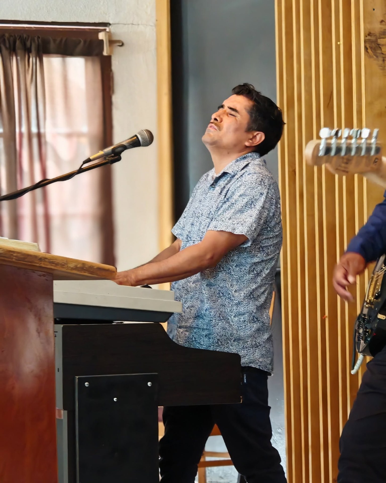 Persona con teclado y micrófono durante una presentación musical.