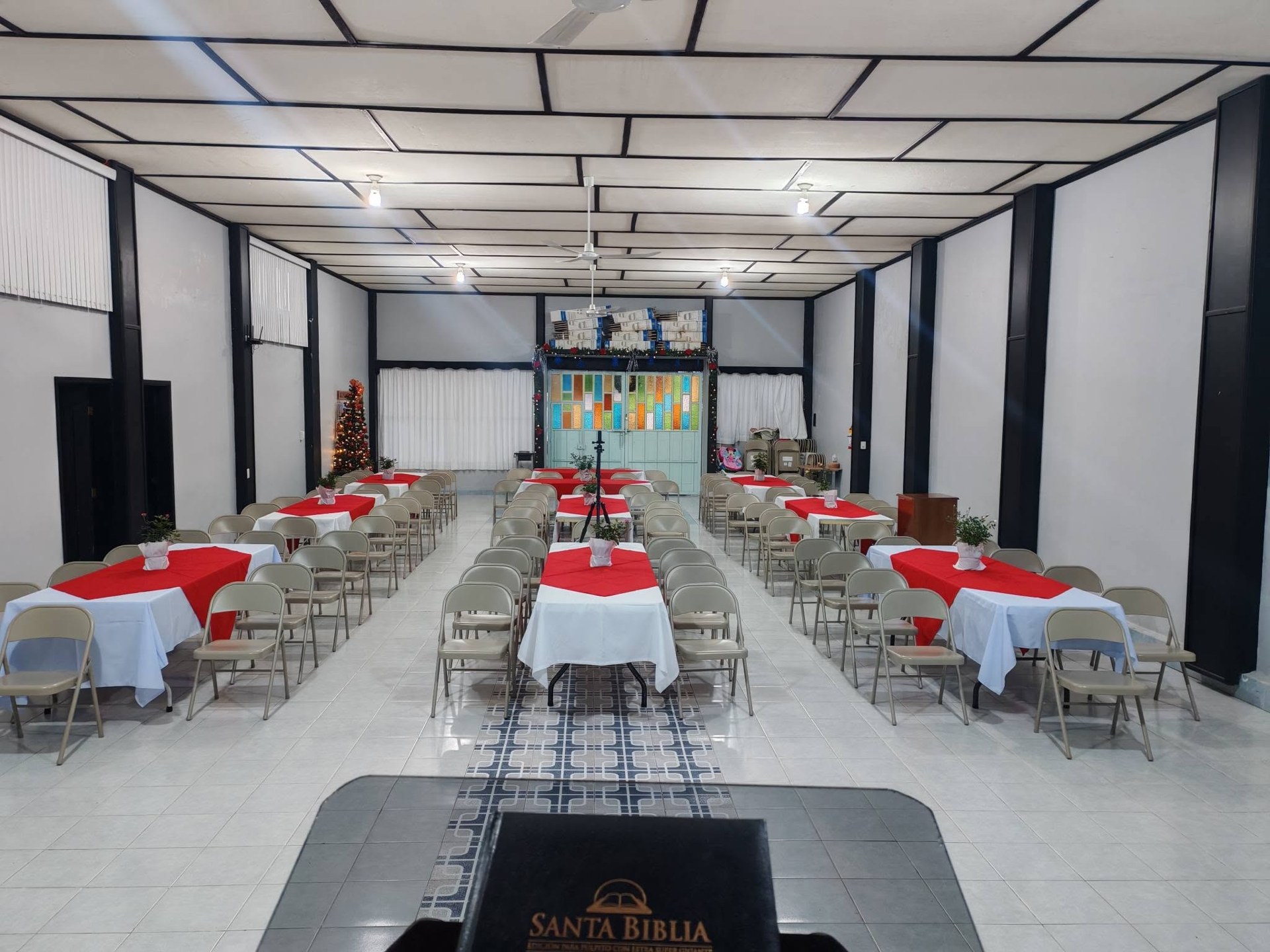 Vista amplia de mesas preparadas en el salón.